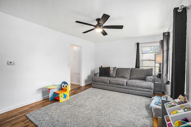 living area featuring baseboards, ceiling fan, and wood finished floors
