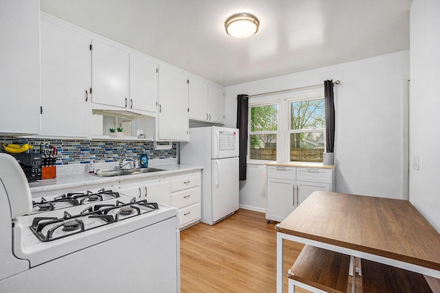 kitchen featuring a sink, white cabinetry, backsplash, and white appliances
