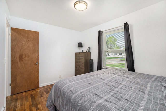 bedroom with baseboards and wood finished floors