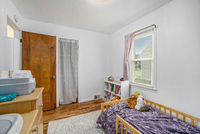 bedroom with visible vents and wood finished floors