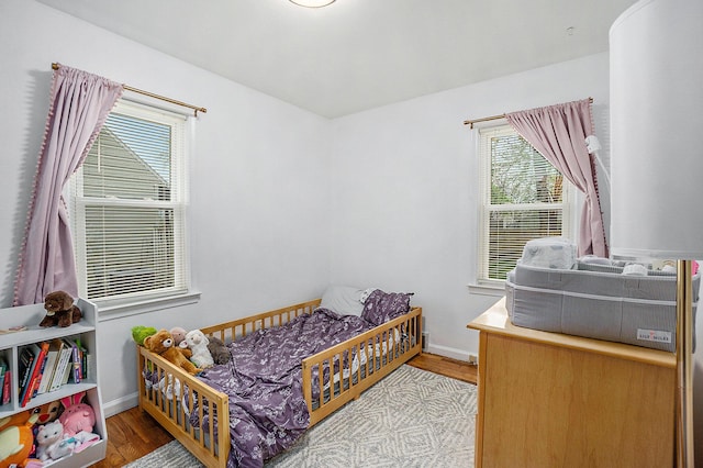 bedroom with baseboards and wood finished floors