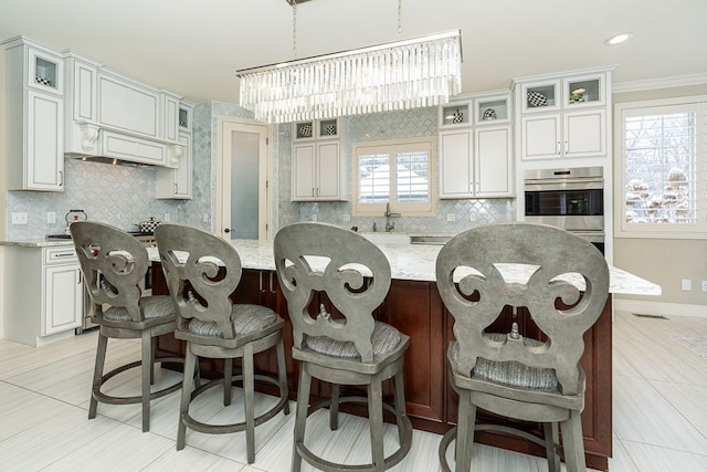 3960 Harvest Creek Ct, Rochester, MI 48306 - kitchen featuring an inviting chandelier, a sink, a center island, backsplash, and glass insert cabinets