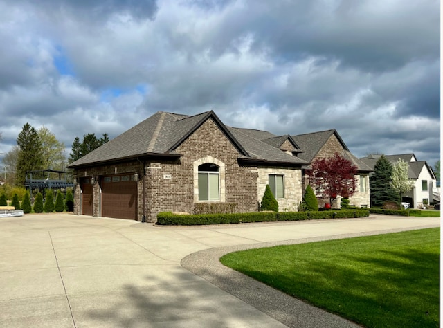 3960 Harvest Creek Ct, Rochester, MI 48306 - french country style house with stone siding, a front yard, roof with shingles, brick siding, and concrete driveway