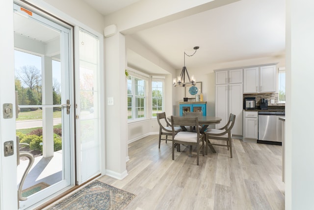 dining area with light wood-style flooring, a chandelier, and baseboards