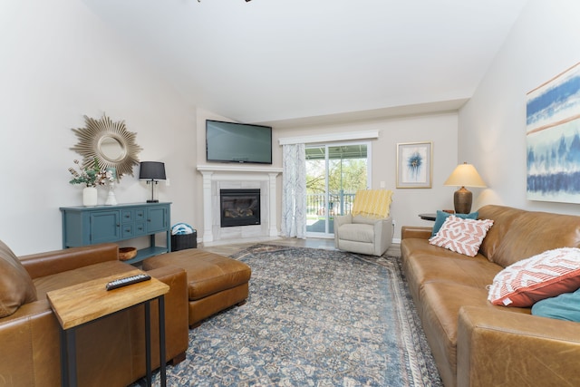 living area featuring a tile fireplace and lofted ceiling