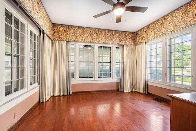 unfurnished room featuring a ceiling fan, baseboards, and wood finished floors