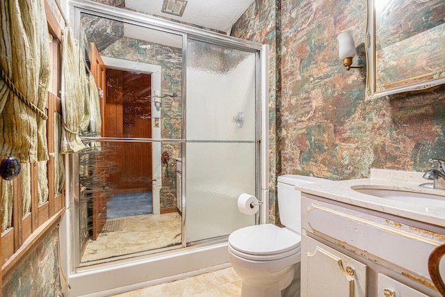 full bathroom with vanity, a stall shower, wallpapered walls, and toilet