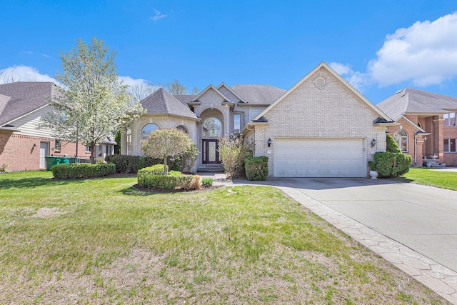 view of front of property featuring brick siding, an attached garage, a front yard, and concrete driveway