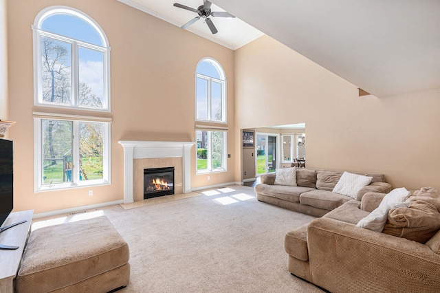 living room with a tiled fireplace, high vaulted ceiling, ceiling fan, and carpet
