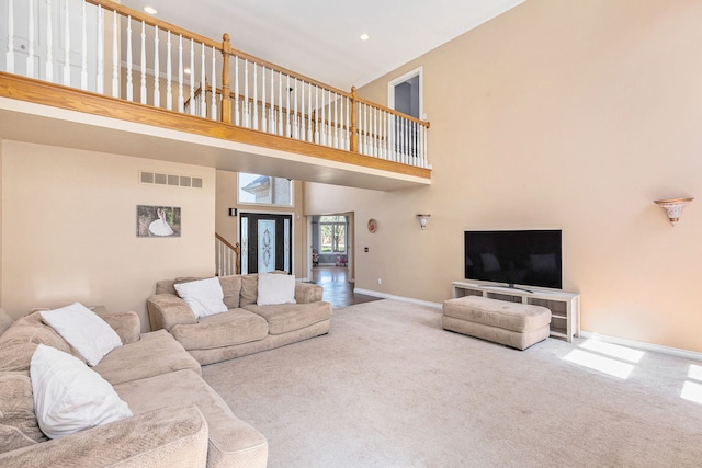 carpeted living room featuring a high ceiling, recessed lighting, baseboards, visible vents, and stairway