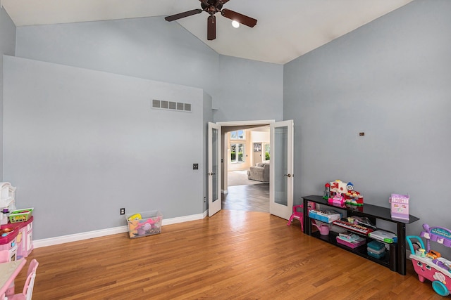 recreation room featuring ceiling fan, high vaulted ceiling, french doors, wood finished floors, and visible vents