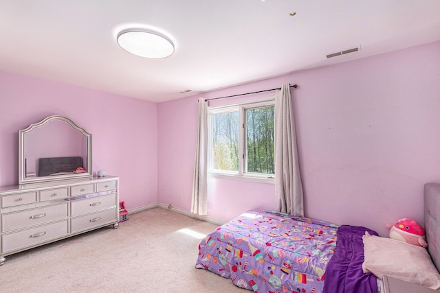 bedroom featuring baseboards, visible vents, and light carpet