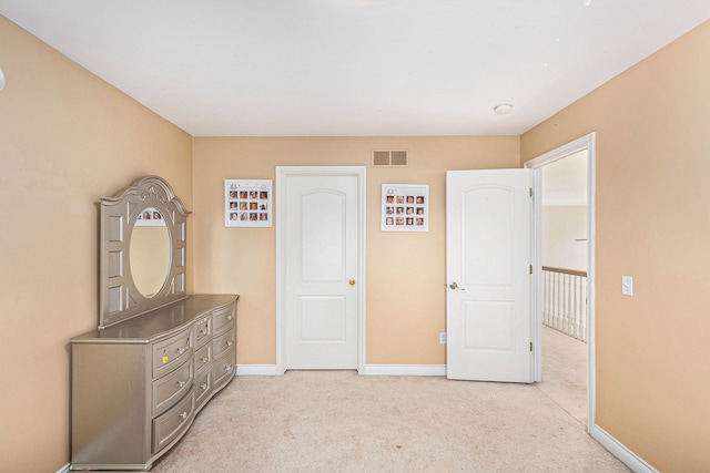 unfurnished bedroom with light colored carpet, baseboards, and visible vents