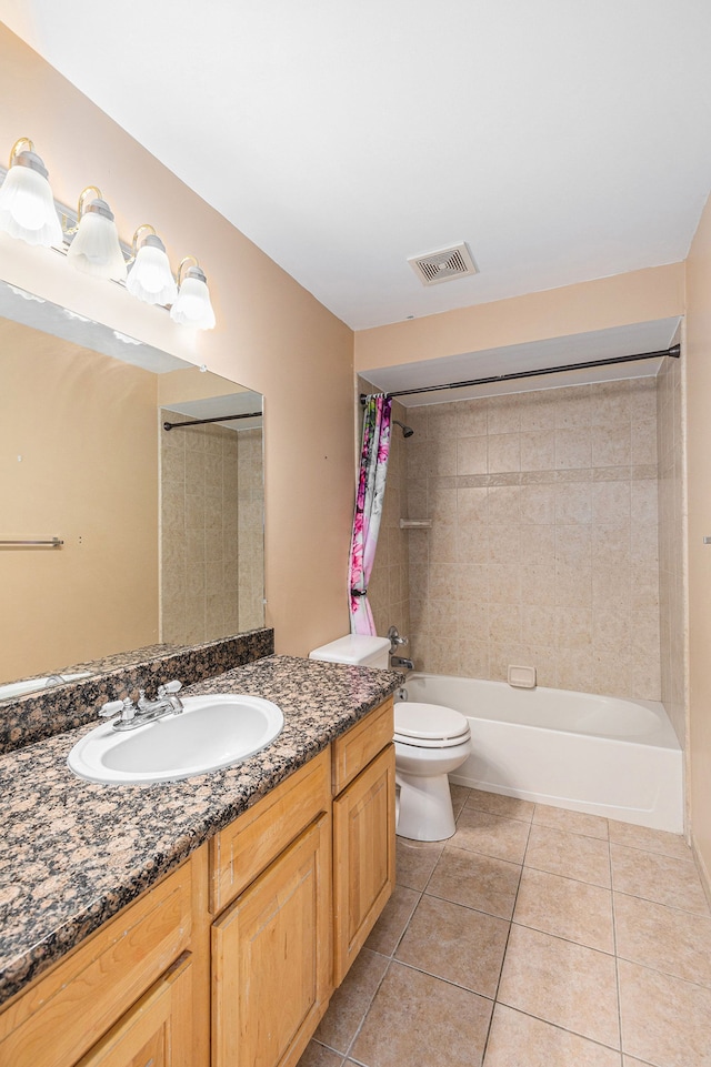 bathroom with visible vents, vanity, toilet, tile patterned floors, and shower / washtub combination