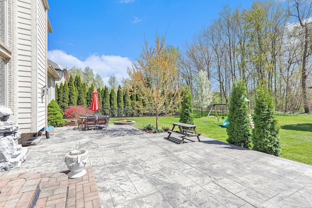 view of patio / terrace featuring outdoor dining area, a playground, and a fire pit
