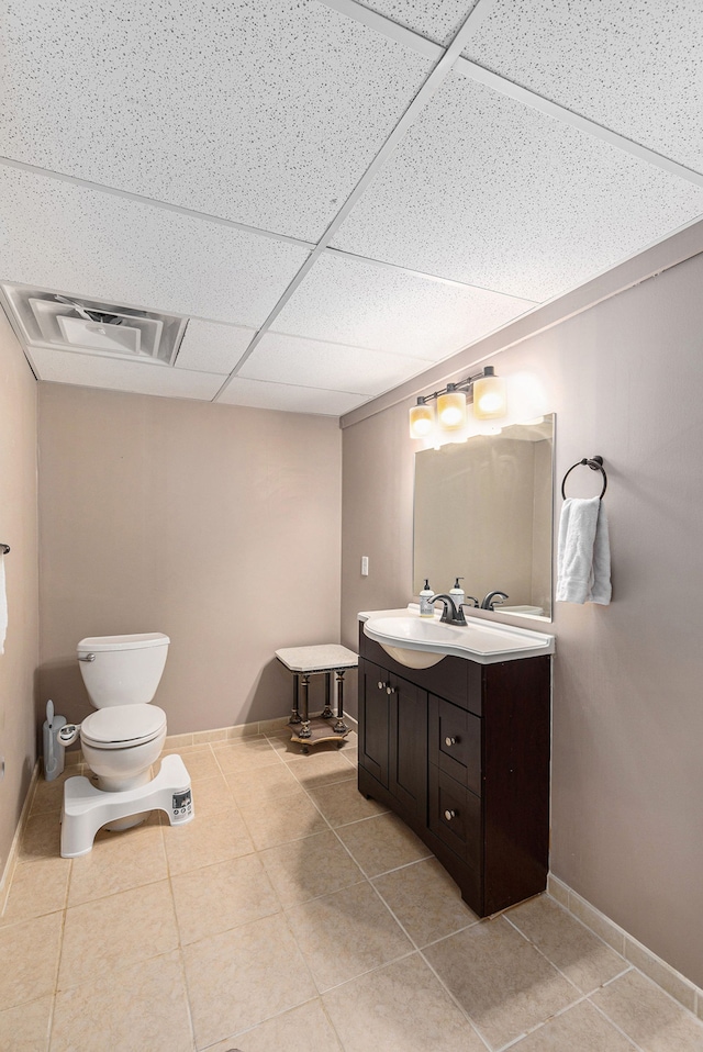 half bath featuring visible vents, tile patterned flooring, vanity, baseboards, and toilet