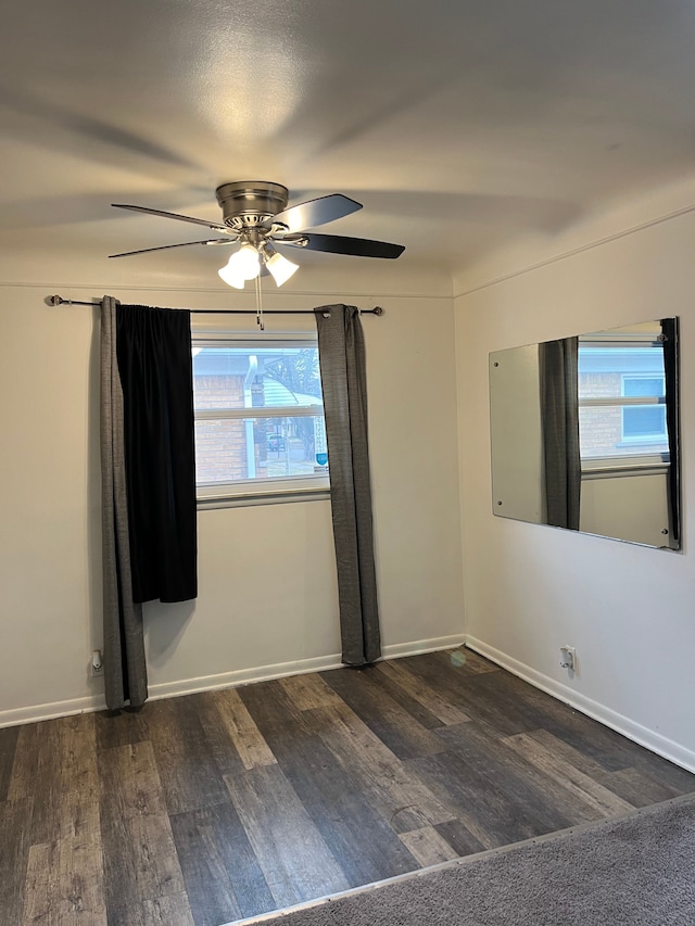 spare room with baseboards, ceiling fan, and wood finished floors