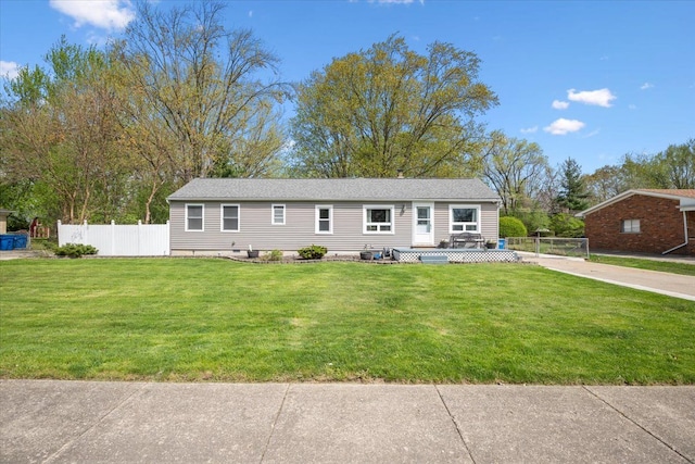 view of front facade featuring fence, a wooden deck, and a front yard