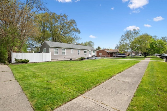 view of front of home featuring fence and a front lawn