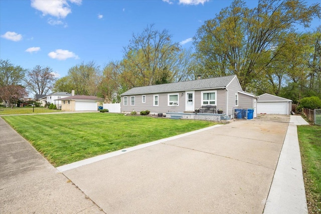 view of front of house featuring a detached garage, fence, an outdoor structure, and a front lawn