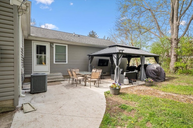 rear view of house with a patio, a gazebo, central AC unit, and a shingled roof