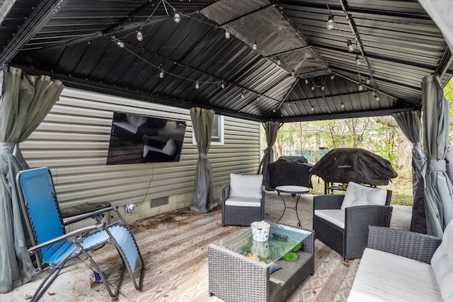 wooden terrace with an outdoor living space and visible vents