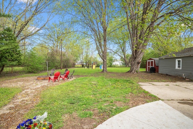view of yard with a storage unit, an outdoor structure, and an outdoor fire pit