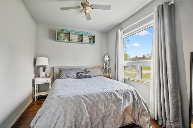 bedroom featuring baseboards, a ceiling fan, and dark wood-style flooring