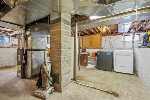 below grade area with heating unit, washing machine and dryer, and plenty of natural light