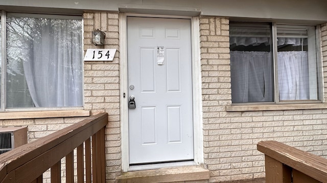 doorway to property with brick siding