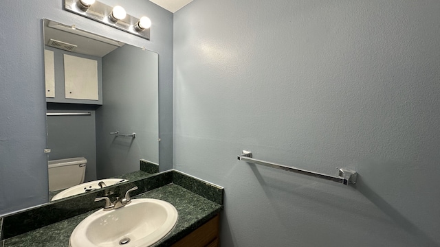 bathroom featuring vanity, visible vents, and toilet