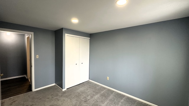 unfurnished bedroom featuring dark carpet, recessed lighting, baseboards, and a closet