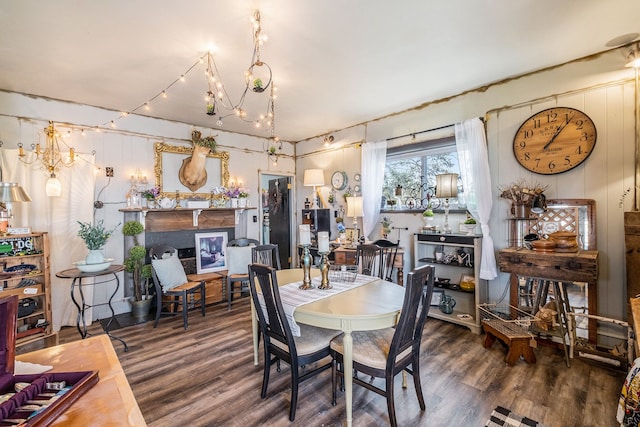 dining space featuring a chandelier, a glass covered fireplace, and wood finished floors