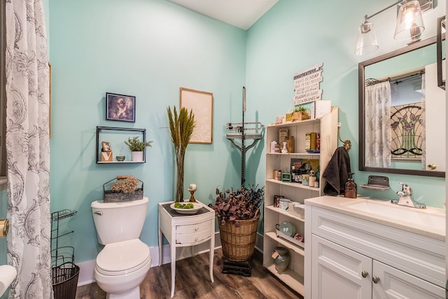 full bath featuring toilet, wood finished floors, and vanity