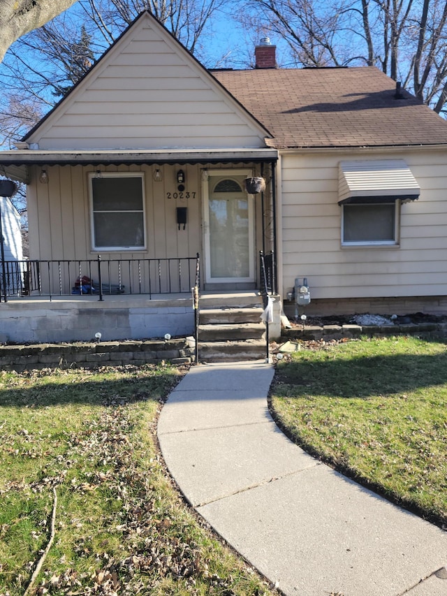 20237 Kingsville St, Harper Woods, MI 48225 - bungalow-style home featuring roof with shingles, covered porch, a chimney, and a front yard