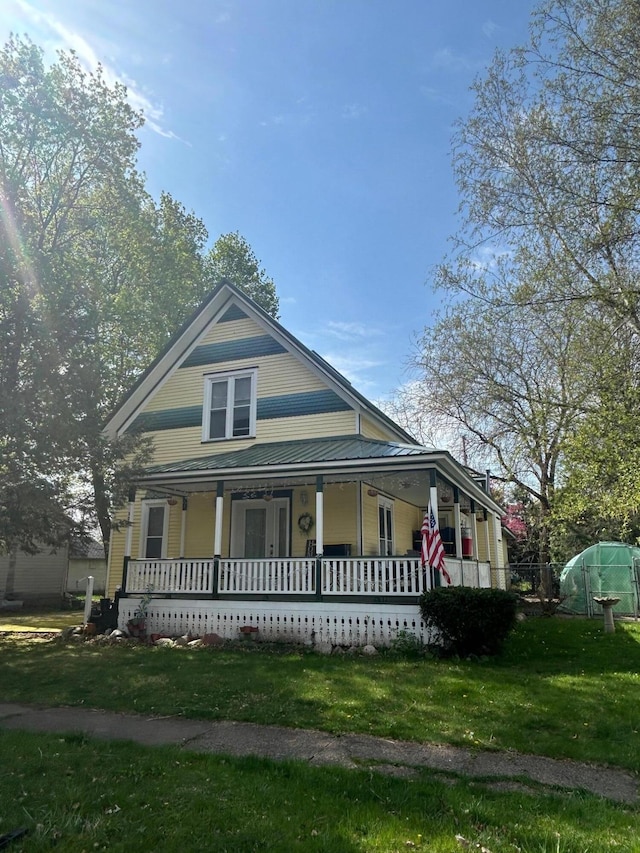 view of front of home with a porch and a front yard