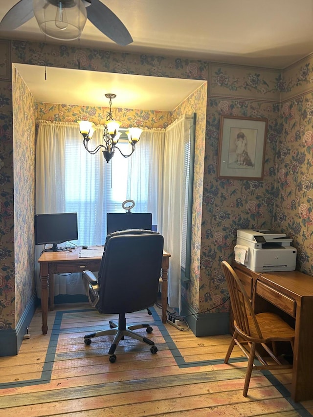 office space featuring wood-type flooring and ceiling fan with notable chandelier