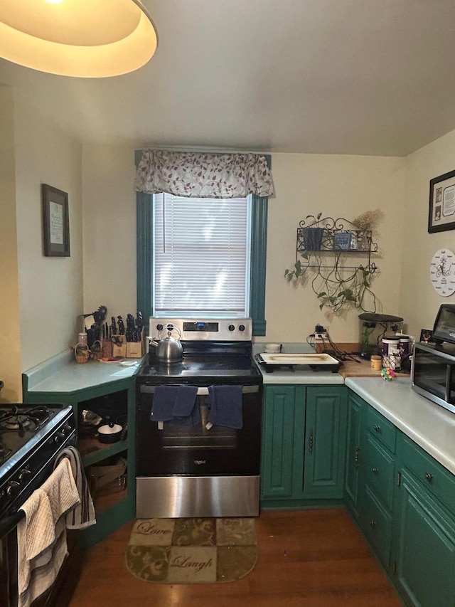 kitchen featuring dark wood-style flooring, black range with gas stovetop, light countertops, green cabinets, and stainless steel electric range oven