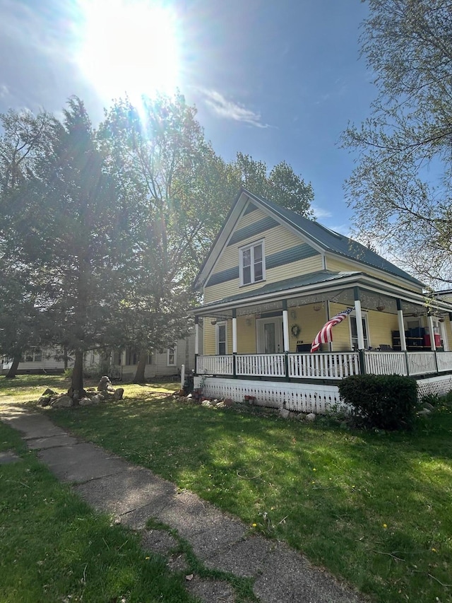 farmhouse featuring a porch and a front lawn