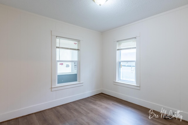unfurnished room featuring baseboards, plenty of natural light, and wood finished floors
