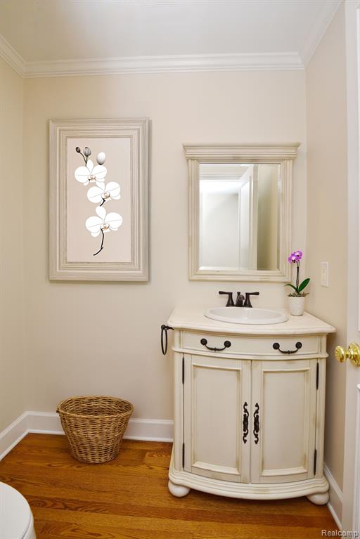 32824 Outland Trl, Bingham Farms, MI 48025 - half bath with vanity, baseboards, crown molding, and wood finished floors