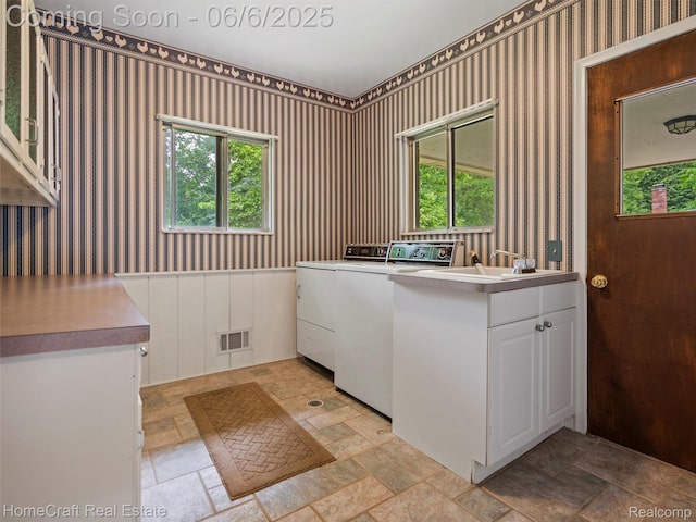 28210 Ridgebrook Rd, Farmington Hills, MI 48334 - washroom with separate washer and dryer, stone tile floors, wallpapered walls, and cabinet space