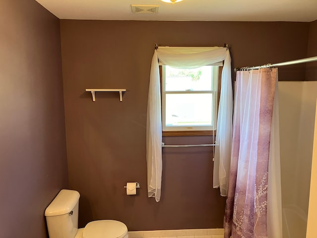 full bathroom featuring a shower with curtain, toilet, and visible vents