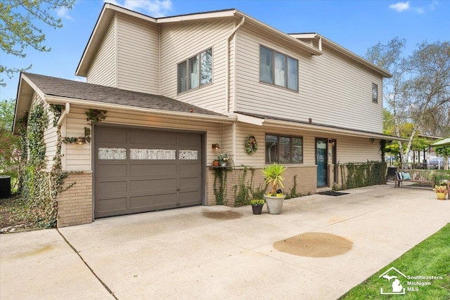 view of front of property featuring central air condition unit, brick siding, and driveway