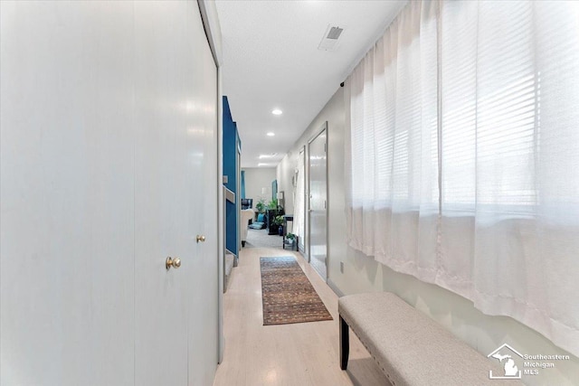 hall with recessed lighting, visible vents, and light wood-type flooring