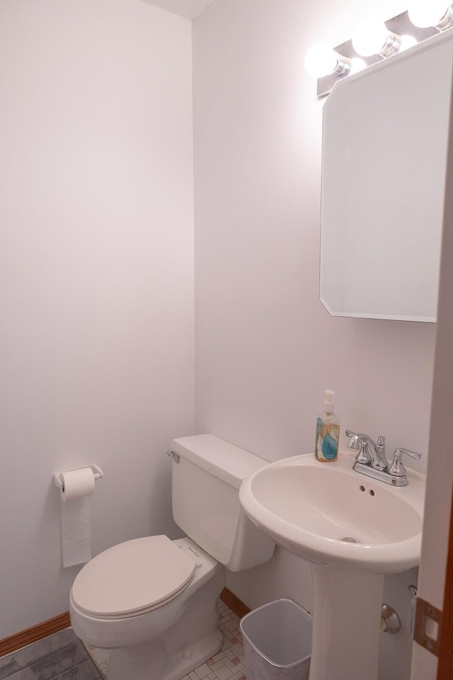 bathroom with baseboards and toilet