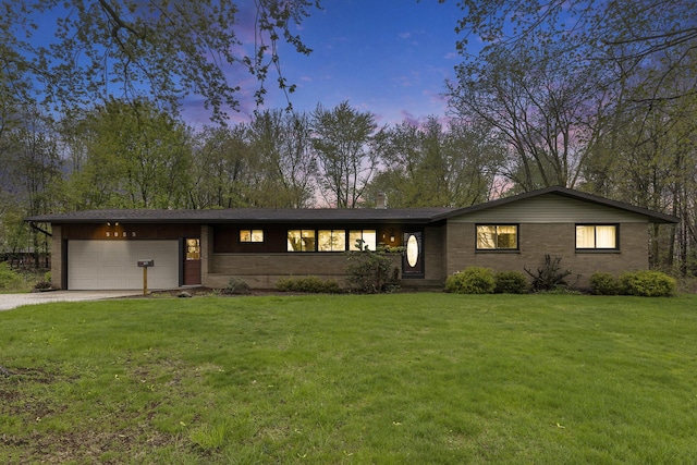 view of front of home featuring a lawn, brick siding, an attached garage, and dirt driveway