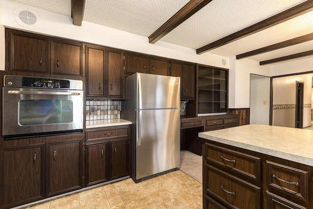 kitchen with dark brown cabinetry, tasteful backsplash, beam ceiling, light countertops, and stainless steel appliances