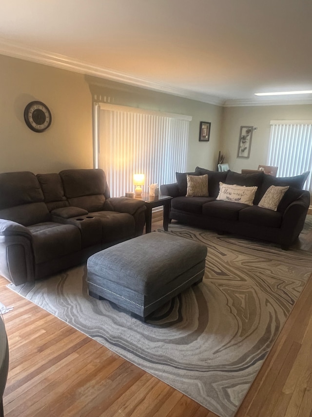 living area with ornamental molding and wood finished floors