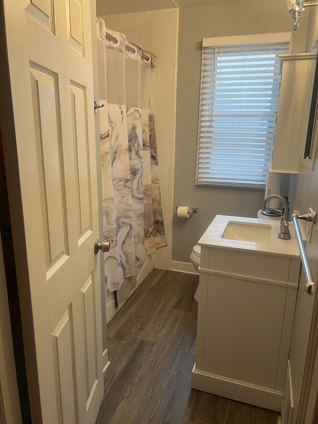full bathroom with vanity, wood finished floors, shower / bath combo, and toilet